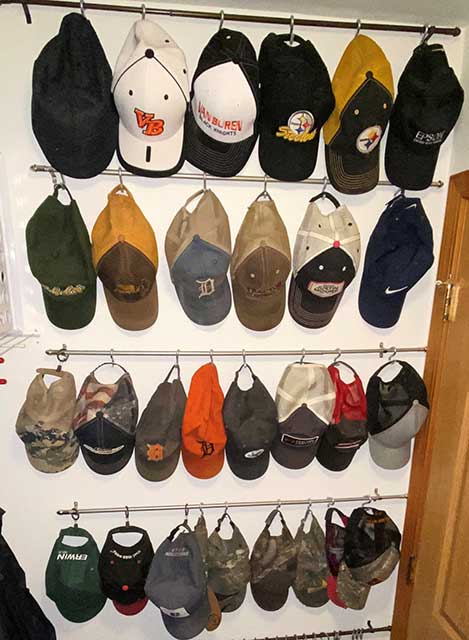 Hats stored on curtain roads on closet wall